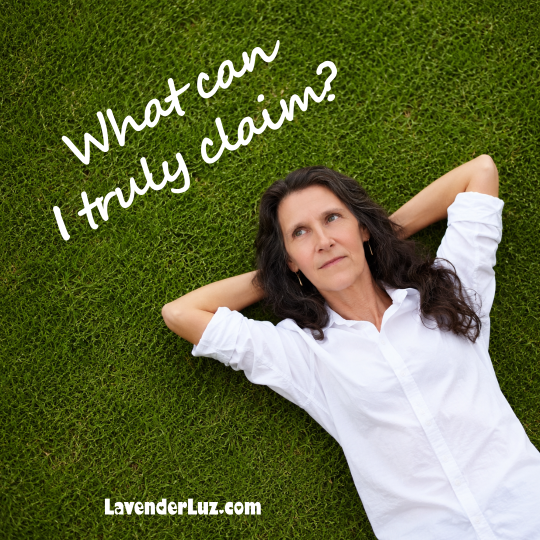 woman in a white shirt lying on grass looking up and wonder what can she truly claim